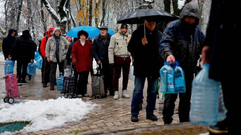 Local residents stand in line to fill up bottles with fresh drinking water after critical civil infrastructure was hit by Russian missile attacks in Kyiv, Ukraine November 24, 2022. REUTERSPIX