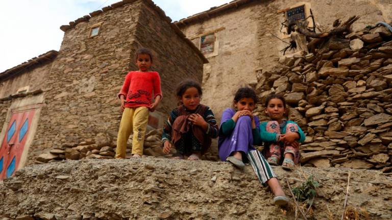 Children affected by a deadly earthquake stand outside a house, in the rural village of Azermoun, Morocco September 14, 2023. - REUTERSPIX