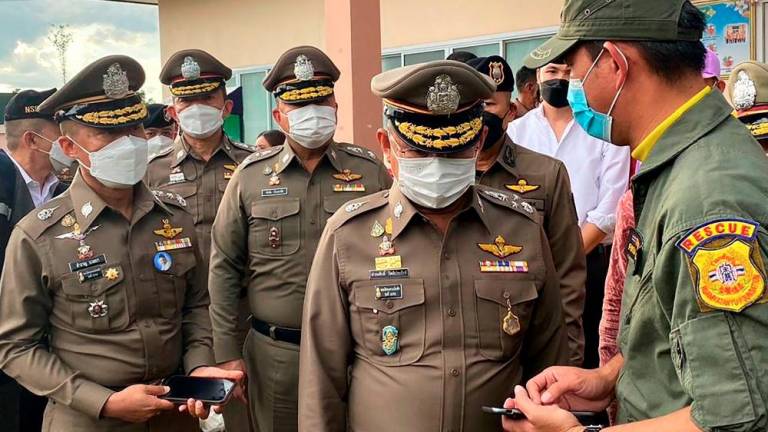 National Police Chief, Damrongsak Kittiprapat (2R), speaking with rescue workers at the nursery following in a mass shooting, in the northern Thai province of Nong Bua Lam Phu. AFPPIX