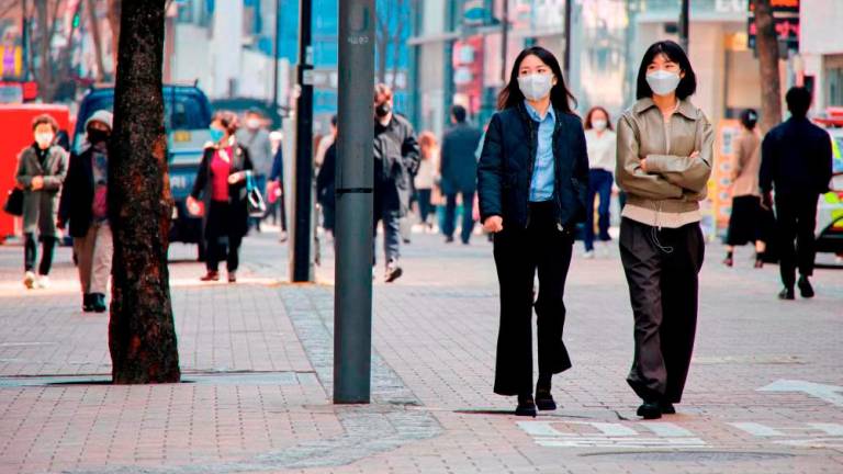 File photo: Women wearing masks walk in a shopping district amid the Covid-19 pandemic in Seoul, South Korea, March 16, 2022. REUTERSpix