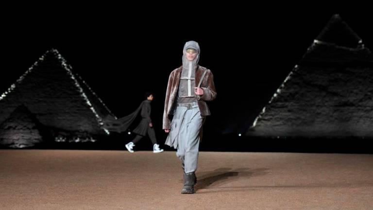 A model presents a creation at the Christian Dior fashion show at the Giza Pyramids Necropolis on the outskirts of the twin city of Egypt's capital on December 3, 2022. French fashion house Dior today held its first show at Egypt's ancient Giza pyramids, presenting its 2023 fall men's collection in the shadow of the of the millennia-old tombs. - AFPPIX