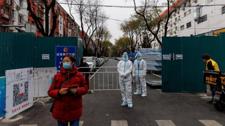 Epidemic-prevention workers standing guard at a residential compound in Beijing on Monday. – Reuterspic