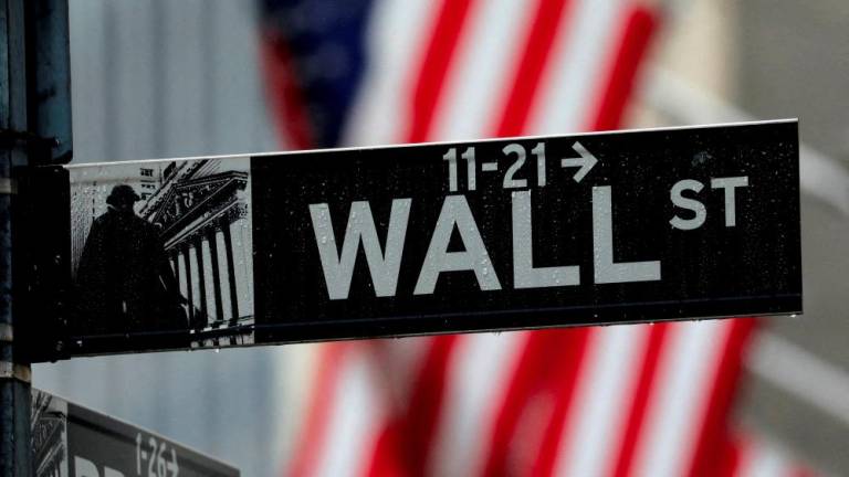 FILE PHOTO: Raindrops hang on a sign for Wall Street outside the New York Stock Exchange in Manhattan in New York City, New York, U.S., October 26, 2020. - REUTERSPIX