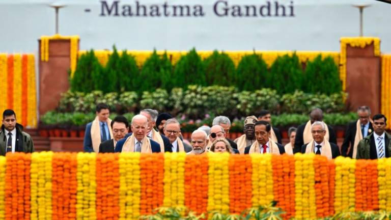 India's Prime Minister Narendra Modi (C) along with world leaders arrive to pay respect at the Mahatma Gandhi memorial at Raj Ghat on the sidelines of the G20 summit in New Delhi on September 10, 2023. AFPPIX