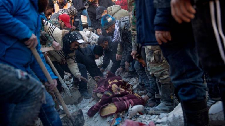 Residents retrieve a body from the rubble of a collapsed building in the regime-controlled town of Jableh in the province of Latakia, northwest of the capital Damscus, on February 8, 2023, two days after a deadly earthquake in Turkey and Syria. AFPPIX