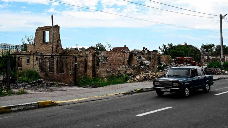 A picture taken on July 3, 2022 shows destroyed buildings in a residential area near Irpin, on Vokzalnaya street, which links the Ukrainian cities of Bucha and Irpin, amid the Russian invasion of Ukraine. AFPPIX