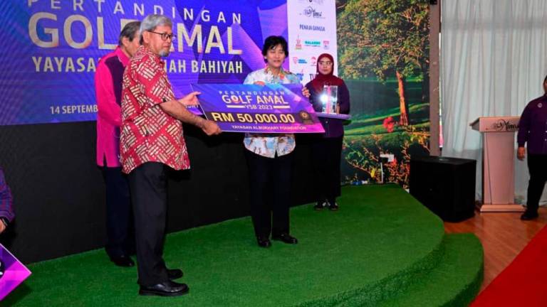 Tan Sri Tunku Puteri Intan Safinaz receiving a mock cheque of RM50,000 from Yayasan Al-Bukhary.