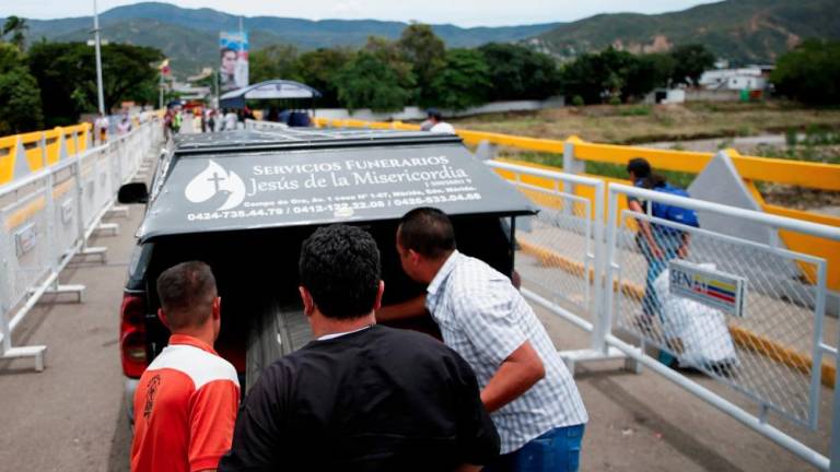 People carry a coffin on the Simon Bolivar International Bridge between Colombia and Venezuela, at a checkpoint before the official reopening of the border, in Cucuta, Colombia September 25, 2022. - REUTERSPIX