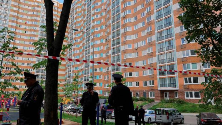 Russian law enforcement officers stand guard near a damaged multi-storey apartment block following a reported drone attack in Moscow, Russia, May 30, 2023. - REUTERSPIX