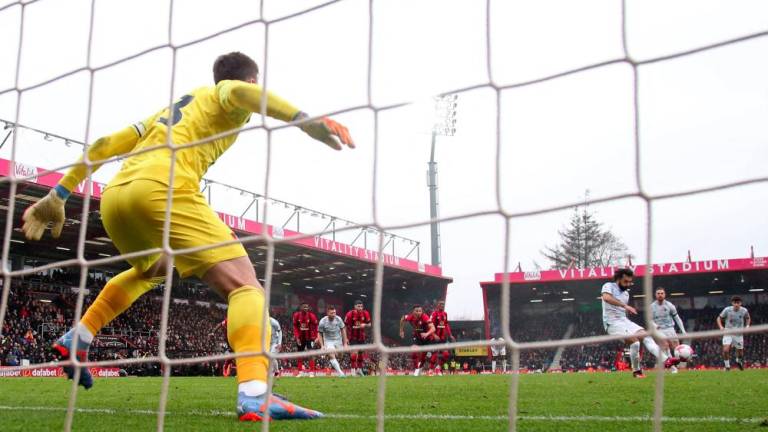 Liverpool's Egyptian striker Mohamed Salah (3R) hits this penalty kick wide of the Bournemouth goal during the English Premier League football match between Bournemouth and Liverpool at the Vitality Stadium in Bournemouth, southern England on March 11, 2023. - AFPPIX