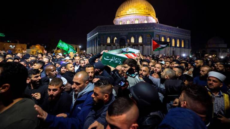Palestinian mourners carry the body of Walid al-Sharif, 23, who died of wounds suffered last month during clashes with Israeli police at Jerusalem’s flashpoint al-Aqsa mosque compound, on May 16, 2022 in front of the Dome of the Rock mosque at the al-Aqsa compound. AFPPIX