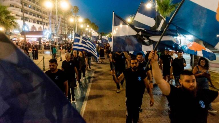 Supporters of the Cypriot far-right National Popular Front (ELAM) wave Greek and party flags as they protest against the presence of illegal immigrants on the Mediterranean island, in Larnaca on June 16, 2023. AFPPIX