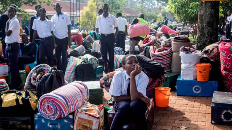 Students wait for their parents with their belongings to leave after a directive of the Health Ministry to close all schools two weeks earlier to curb the spread of Ebola at Naalya Senior Secondary boarding school in Kampala on November 25, 2022. AFPPIX