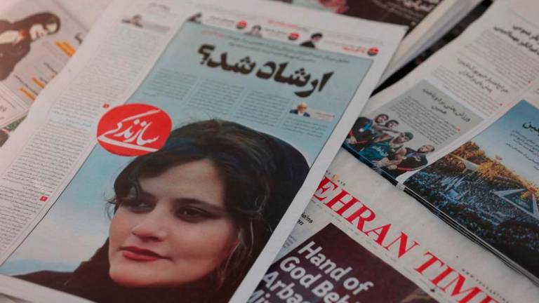 FILE PHOTO: A newspaper with a cover picture of Mahsa Amini, a woman who died after being arrested by the Islamic republic’s “morality police” is seen in Tehran, Iran September 18, 2022/REUTERSPix
