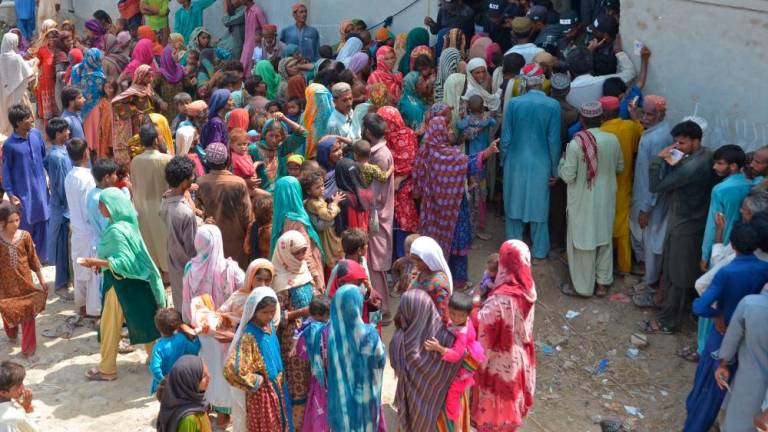 Internally displaced flood-affected people wait to receive charity relief supplies near a makeshift camp at Dera Allah Yar in Jaffarabad district of Balochistan province on September 21, 2022. AFPPIX