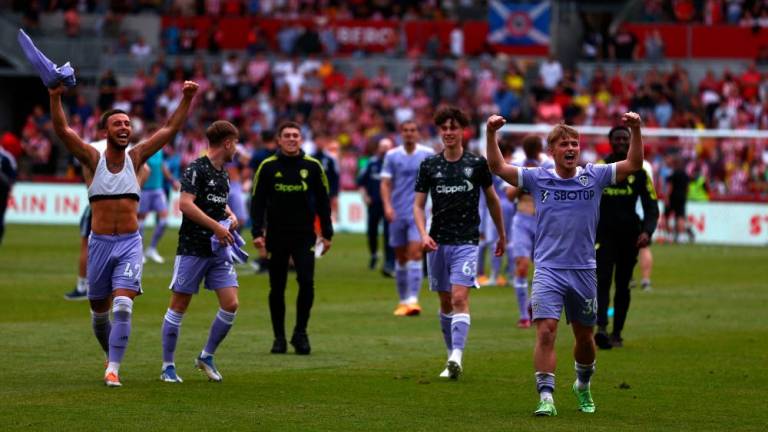 Leeds United’s players celebrate on the pitch after the English Premier League football match between Brentford and Leeds United at Brentford Community Stadium in London on May 22, 2022. AFPPIX