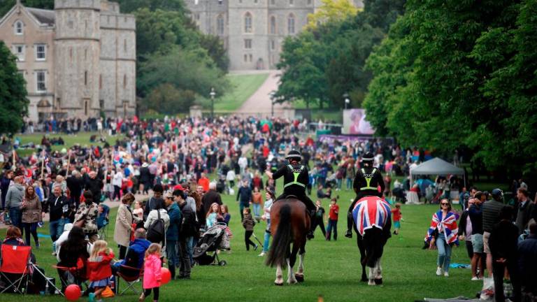 FILE PHOTO: Police officers ride on horses past the crowd as people take part in the Big Jubilee Lunch on The Long Walk as part of celebrations marking the Platinum Jubilee of Britain's Queen Elizabeth, in Windsor, Britain, June 5, 2022. REUTERSPIX