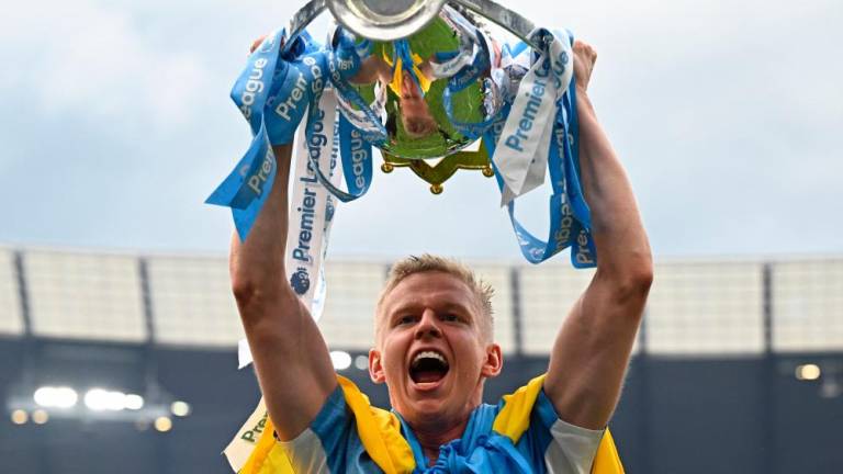 Manchester City’s Ukrainian midfielder Oleksandr Zinchenko celebrates with the Premier league trophy on the pitch after the English Premier League football match between Manchester City and Aston Villa at the Etihad Stadium in Manchester, north west England, on May 22, 2022. AFPPIX