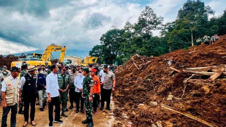 This handout picture taken and released on November 22, 2022 by the Indonesia’s Presidential Palace shows the President Joko Widodo (L, white shirt) as he visits Cianjur following a 5.6-magnitude earthquake. AFPPIX