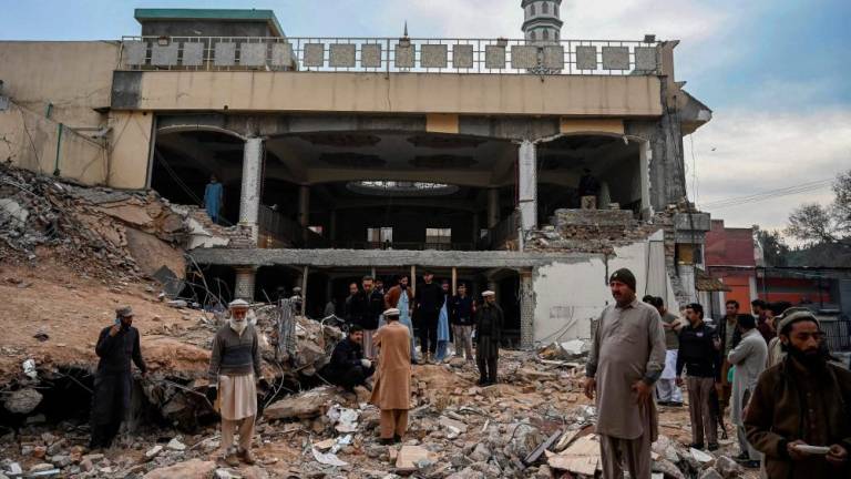 Plain-clothed policemen inspect the site as they gather over the rubble of a damaged mosque following January’s 30 suicide blast inside the police headquarters in Peshawar on February 1, 2023. AFPPIX