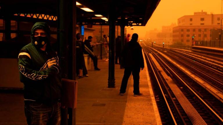 NEW YORK, NEW YORK - JUNE 7: A person waiting for the subway wears a filtered mask as smoky haze from wildfires in Canada blankets a neighborhood on June 7, 2023 in the Bronx borough of New York City. AFPPIX