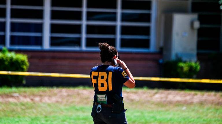 An FBI agent is seen outside Robb Elementary School in Uvalde, Texas, on May 25, 2022. AFPPIX