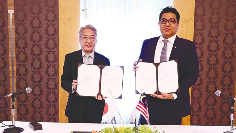 Tengku Muhammad Taufik (right) and Hosono displaying the signed documents.