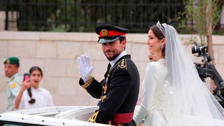 ordan’s Crown Prince Hussein (L) and his wife Saudi Rajwa al-Seif leave in a convoy following their royal wedding ceremony in Amman on June 1, 2023. AFPPIX