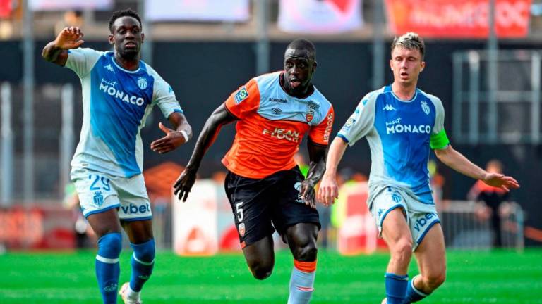Benjamin Mendy (C) fights for the ball with Folarin Balogun (L) and Aleksandr Golovin during the French L1 football match between FC Lorient and AS Monaco at Stade du Moustoir in Lorient, western France on September 17, 2023. AFPPIX