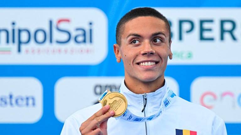 Gold medallist Romania’s David Popovici poses on the podium after winning and setting a new world record of the Men’s 100m freestyle final event on August 13, 2022 at the LEN European Aquatics Championships in Rome. AFPPIX
