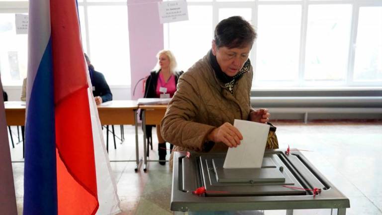 A woman casts her ballot for a referendum at a polling station in Mariupol on September 27, 2022. AFPPIX