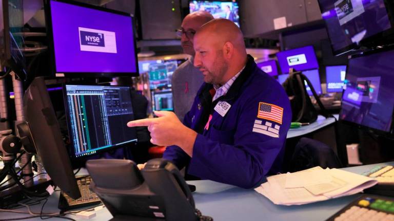 Traders work on the floor of the New York Stock Exchange during afternoon trading on Monday, Oct 3. US stocks started the fourth quarter of the year on a positive note. – AFPpix