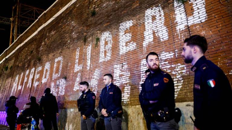 Police officers stand near a writing on a wall asking for freedom for Italian anarchist Alfredo Cospito, who is in jail under the strict “41 bis” isolation regime, in Rome, Italy, January 31, 2023. Writing on the wall reads: “Free Alfredo. No to 41 bis”. REUTERSPIX