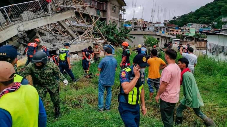 This handout photo taken from the Facebook page of La Trinidad Municipal Police Station shows a rescue team at the site of a collapsed building in La Trinidad, in the province of Benguet on July 27, 2022, after a 7.0-magnitude earthquake hit the northern Philippines. AFPPIX