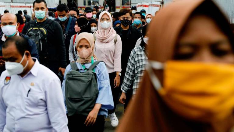 FILE PHOTO: People wearing protective masks walk through a platform of a train station during the afternoon rush hours as the Omicron variant continues to spread, amid the coronavirus disease (Covid-19) pandemic, in Jakarta, Indonesia, January 3, 2022. REUTERSPIX