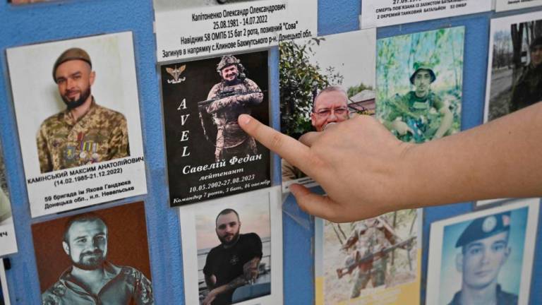 Erika Martyniuk shows the photograph of her late husband Savely Fedan on the Memory Wall of Fallen Defenders of Ukraine during an interview with AFP in Kyiv on September 14, 2023, amid the Russian invasion of Ukraine. AFPPIX