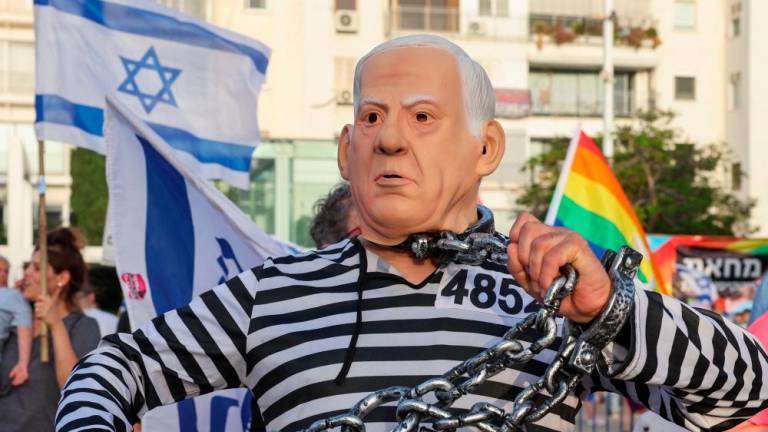 A demonstrator wearing a costume depicting Israeli Prime Minister Benjamin Netanyahu in a prison uniform takes part in a rally protesting the Israeli government’s judicial overhaul bill in Tel Aviv on June 3, 2023/AFPPix