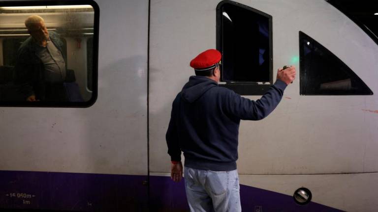 A station master shows the green light to the train driver at Athens central train station as Greece resumes some train routes weeks after a deadly train crash in Athens, Greece March 22, 2023. REUTERSPIX