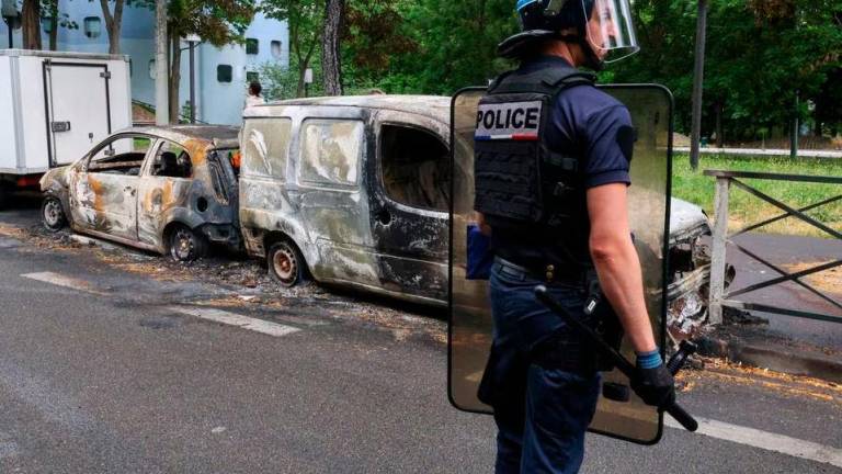 A French police officer stands guard next to vehicles burnt during a night of clashes between protesters and police, following the death of a 17-year-old teenager killed by a French police officer during a traffic stop, in Nanterre, Paris suburb, France, July 1, 2023. REUTERSPIX