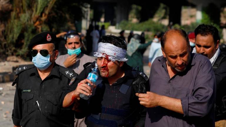 A police officer, who was injured during clashes with the supporters of Pakistan’s former Prime Minister Imran Khan, drinks water as he leaves the protest site in Peshawar, Pakistan, May 10, 2023/AFPpix