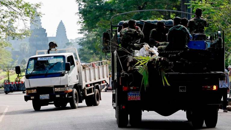 This file photo taken on January 18, 2023 shows a military truck transporting the belongings of a resident past the Angkor Wat temple in Siem Reap province. AFPPIX