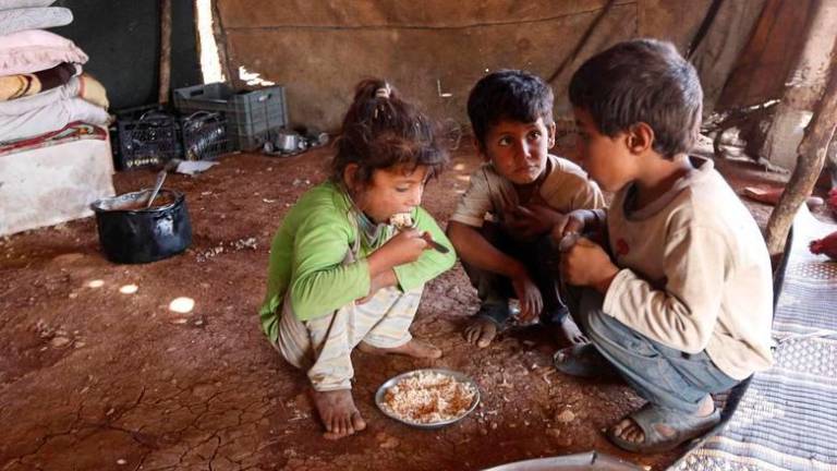 Internally displaced children, who along with their family fled the violence in Aleppo’s Handarat area, eat inside a tent in the northern countryside of Aleppo, October 8, 2014. REUTERSPIX