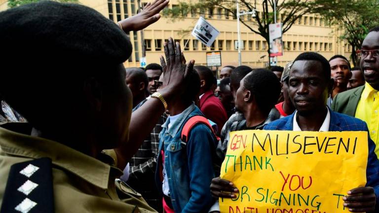 A Ugandan police officer directs students as they participate in a peaceful walk to appreciate President Yoweri Museveni for signing the new anti-homosexuality law in Kampala, Uganda May 31, 2023/AFPPix