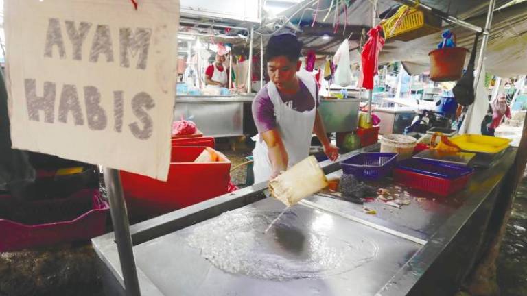 A trader washing up the area after supply of fresh poultry at his stall was sold out as early as 8am at the Bukit Mertajam market yesterday. – MASRY CHE ANI/THESUN
