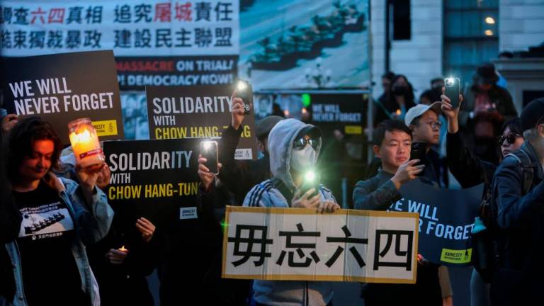 People hold candles and torches at a vigil marking the 34th anniversary of China’s 1989 crackdown on pro-democracy protestors around Beijing’s Tiananmen Square and in solidarity with blank paper protestors, outside the Chinese Embassy in London, Britain, June 4, 2023/REUTERSPix