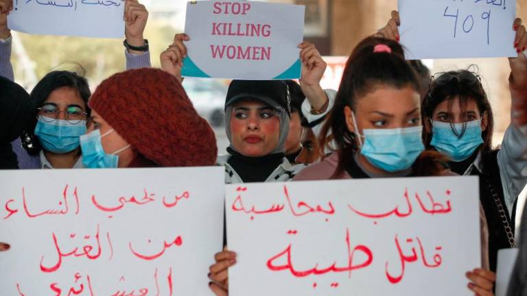 Iraqi women's rights activists lift placards during a rally near the Supreme Judicial Council in Baghdad on February 5, 2023, to protest the killing of Iraqi youtuber Tiba al-Ali by her father in Diwaniyah. - AFPPIX