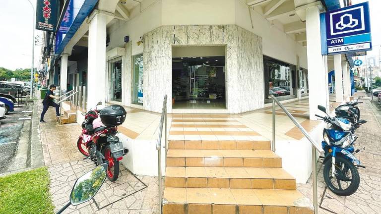 Accessing buildings without PWD-friendly facilities is a daunting task for people in wheelchairs. – Adib Rawi Yahya/theSun