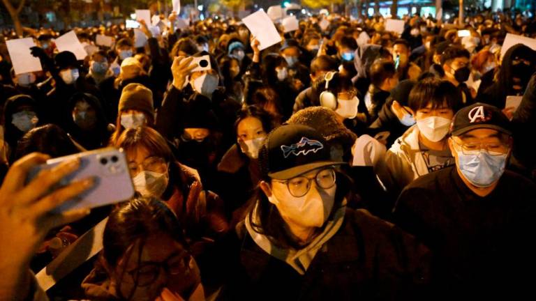 Protesters march along a street during a rally for the victims of a deadly fire as well as a protest against China’s harsh Covid-19 restrictions in Beijing on November 28, 2022. AFPPIX