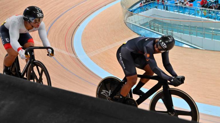 Muhammad Shah Firdaus Sahrom (R) and Japan's Shinji Nakano (L) compete in the men's sprint quarterfinal race 2 of the cycling track event during the 2022 Asian Games in Hangzhou//AFPix