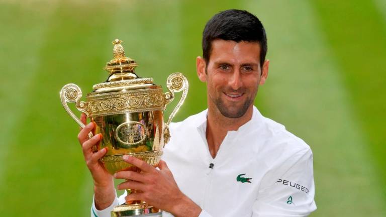 FILE PHOTO: Tennis - Wimbledon - All England Lawn Tennis and Croquet Club, London, Britain - July 11, 2021 Serbia’s Novak Djokovic celebrates with the trophy after winning his final match against Italy’s Matteo Berrettini REUTERSpix